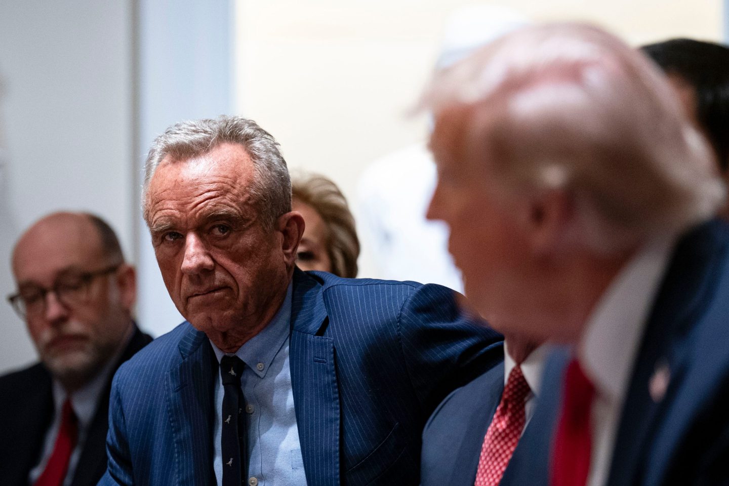 Robert F. Kennedy Jr. looks forward, while Donald Trump looks back at him.