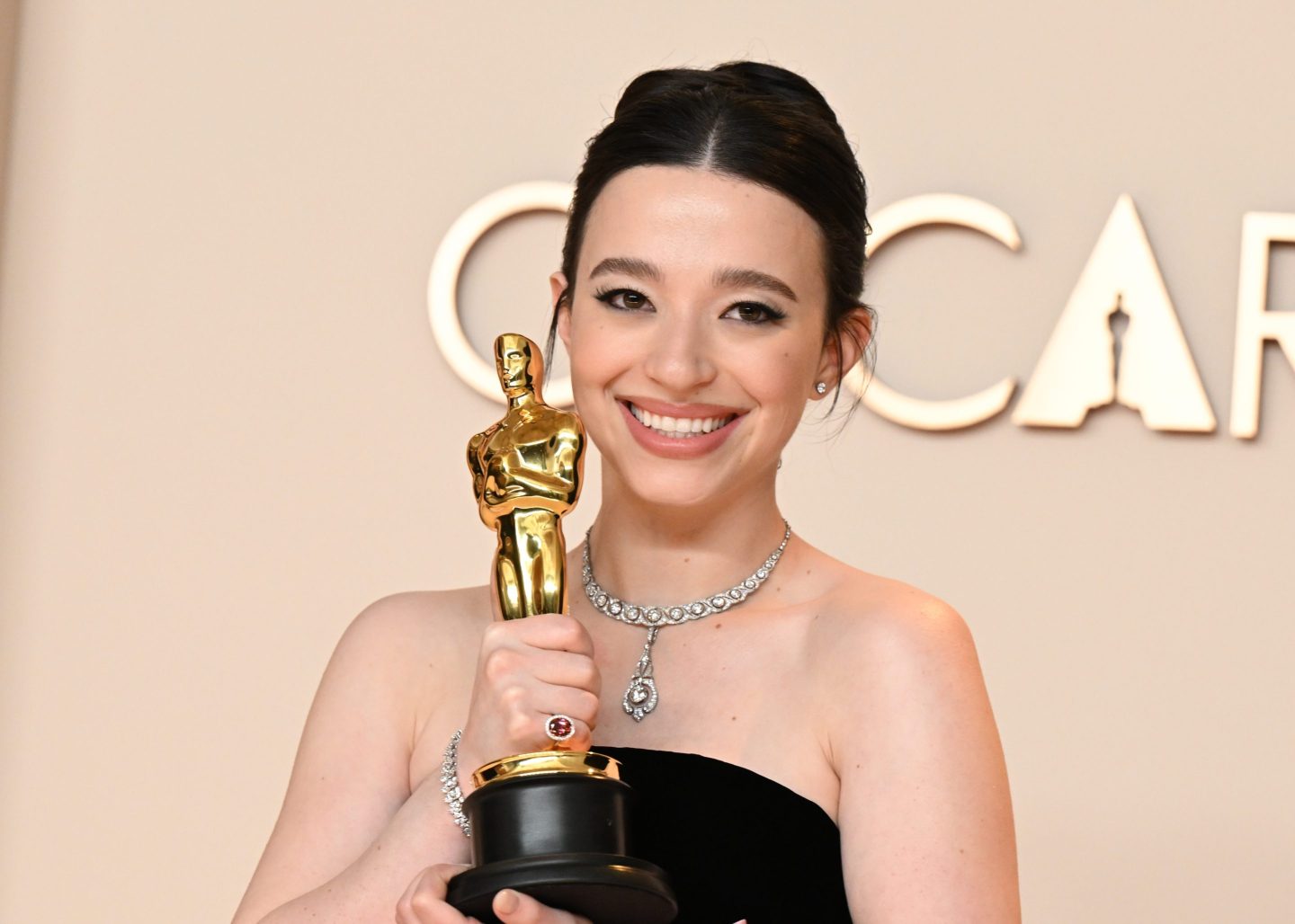 Mikey Madison holding an Oscar