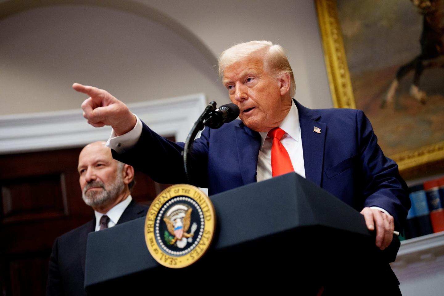 President Donald Trump pointing while standing at a podium.
