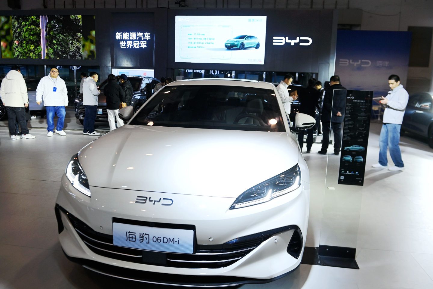 People surround a BYD car on a showroom floor