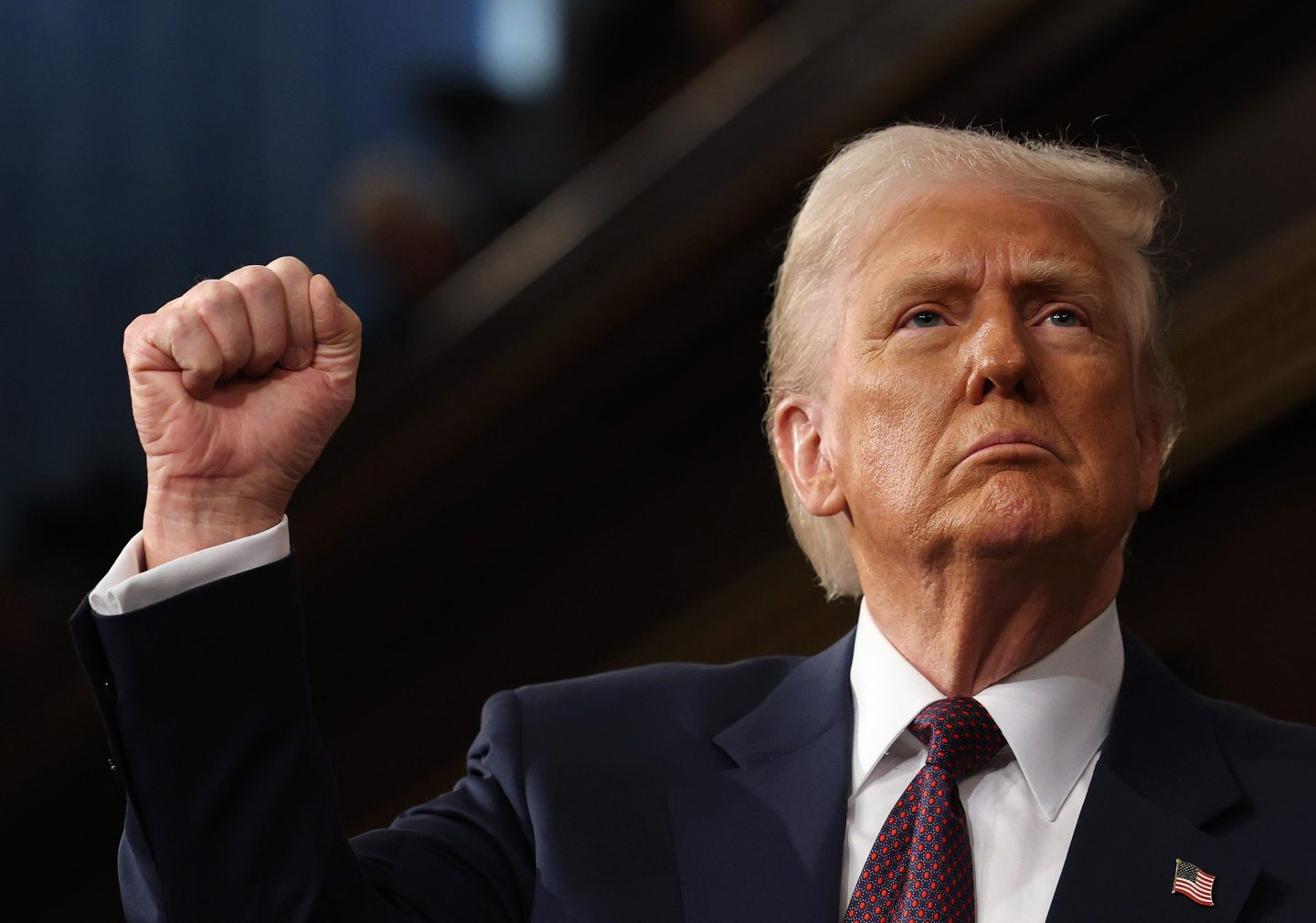 President Donald Trump raises his right hand into a fist.
