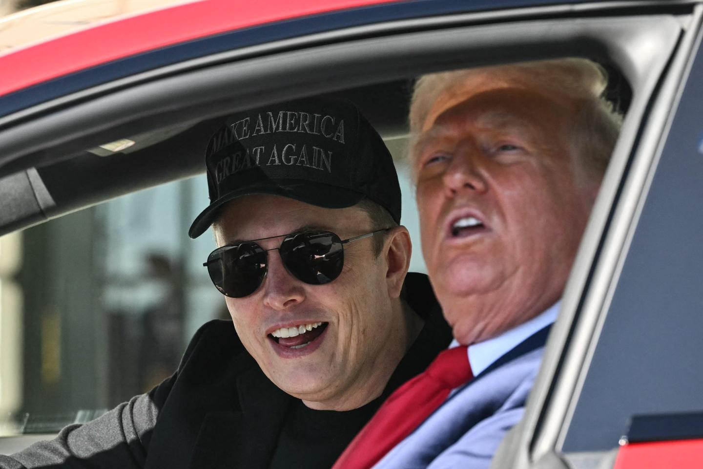 US President Donald Trump and Tesla CEO Elon Musk speak to the press as they sit in a Tesla vehicle on the South Portico of the White House.