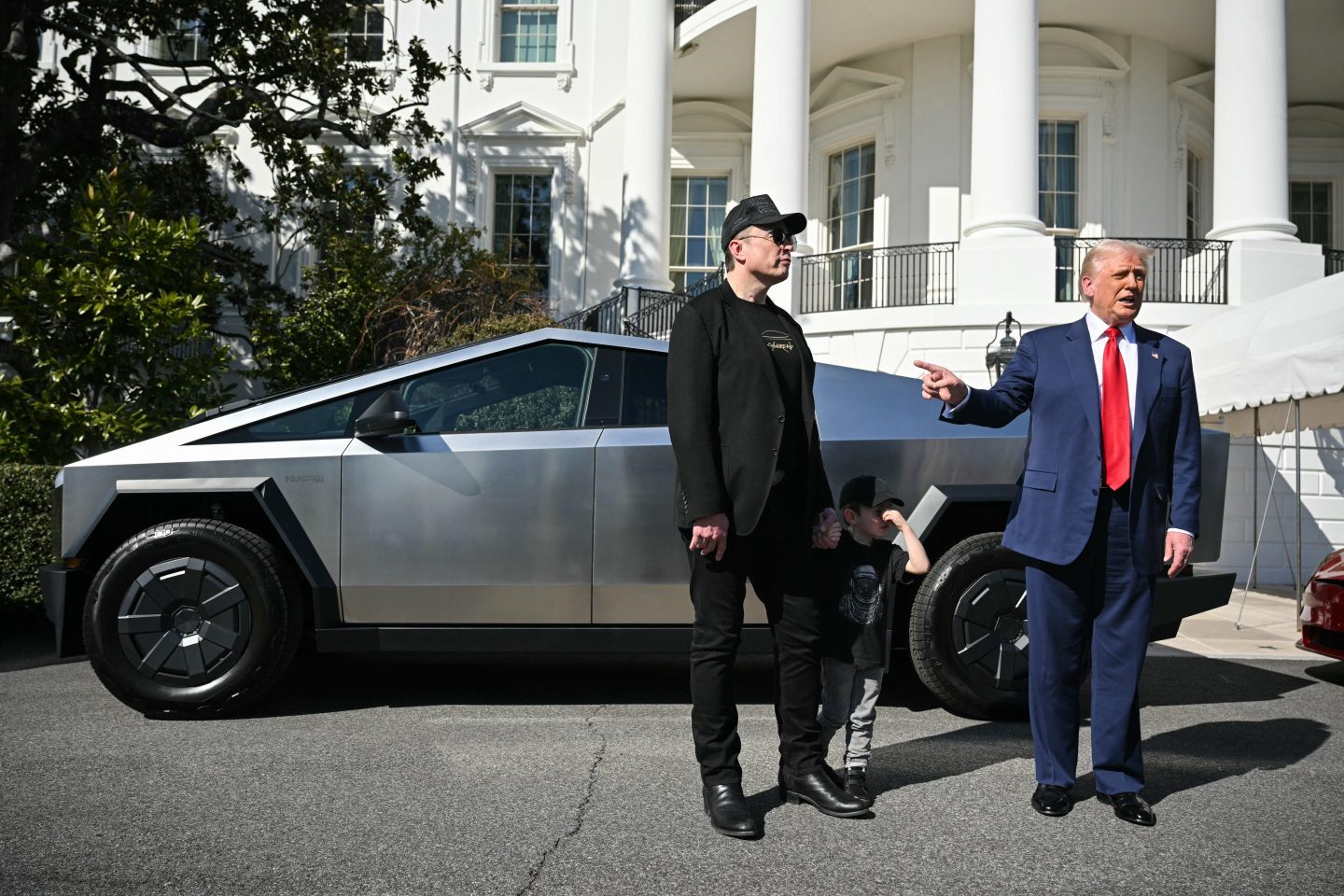 US President Donald Trump and Tesla CEO Elon Musk speak to the press as they stand next to a Tesla Cybertruck on the South Portico of the White House.