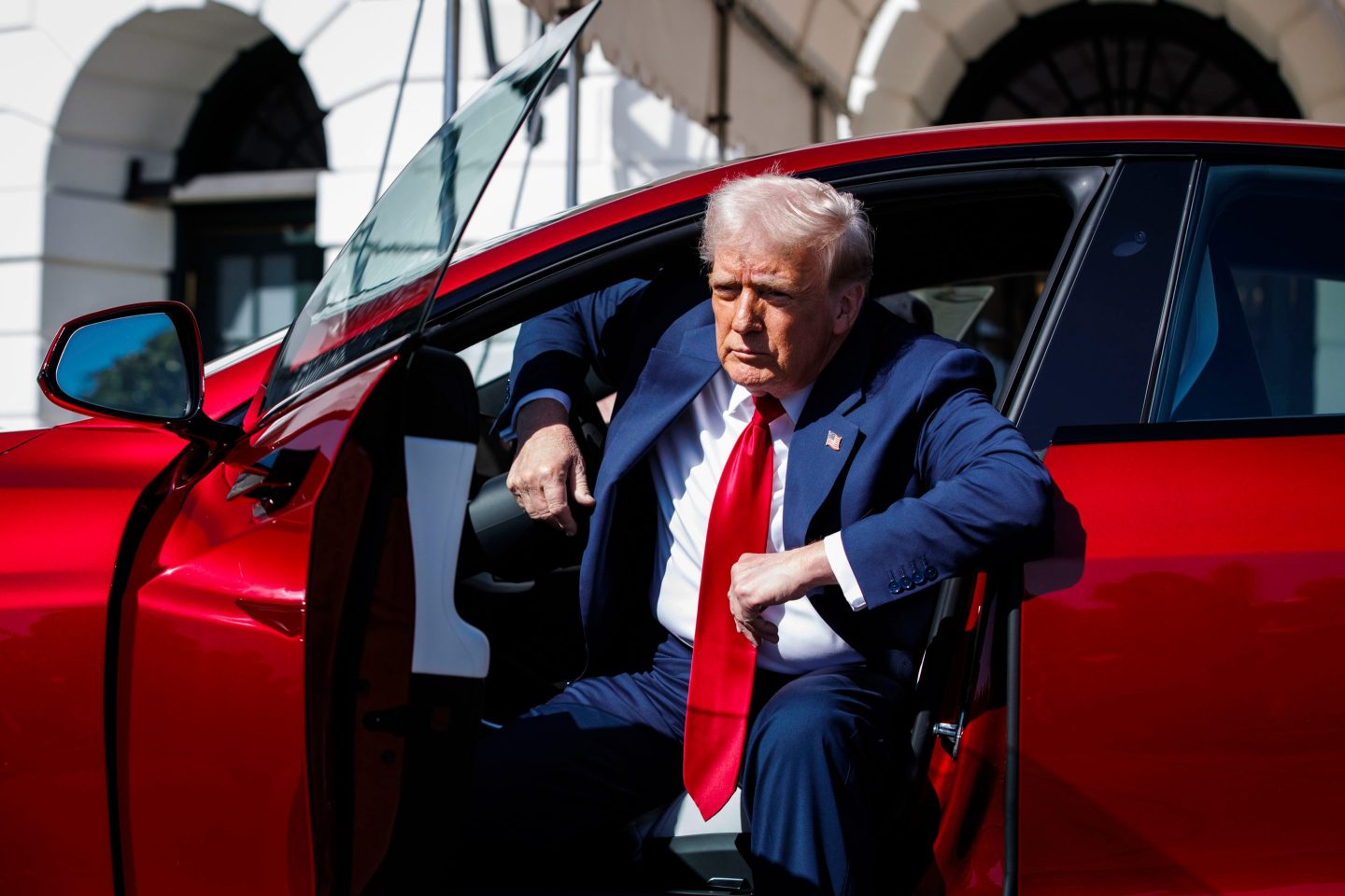 Donald Trump getting out of a red car