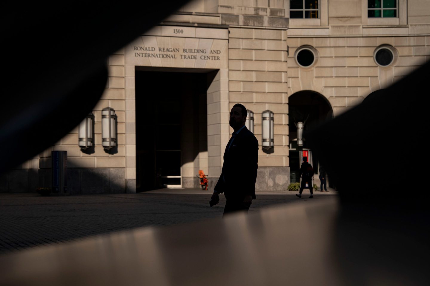 A federal worker walking with a shadow background.