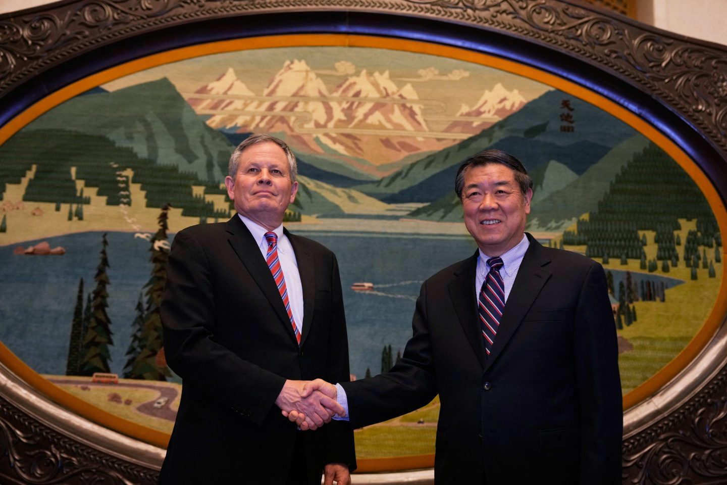Chinese Vice Premier He Lifeng (R) shakes hands with U.S. Senator Steve Daines before a meeting held in the Xinjiang Room at the Great Hall of the People in Beijing on March 22, 2025.