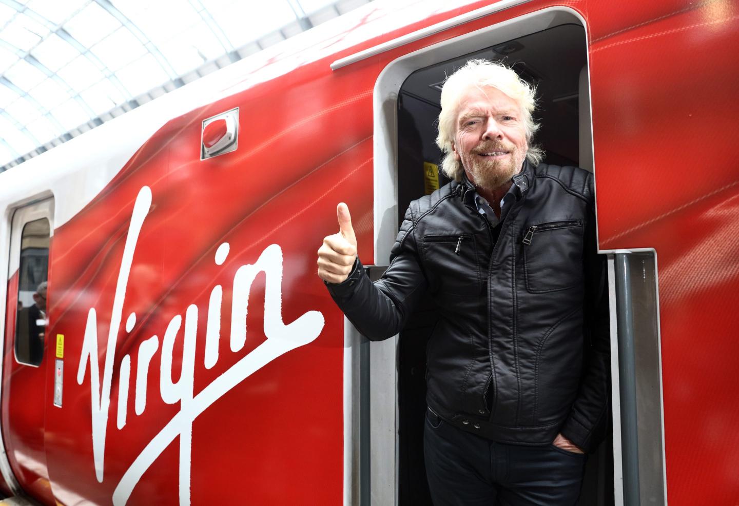 Richard Branson, chairman and founder of Virgin Group Ltd., poses for a photograph on board a new Virgin Azuma high speed train, manufactured by Hitachi Ltd., at Kings Cross station, London, U.K., on Friday, March 18, 2016. Virgin Trains will revive plans to offer high-speed Internet access on Europes busiest rail route in a bid to beat the plane and persuade business people to travel outside peak hours.