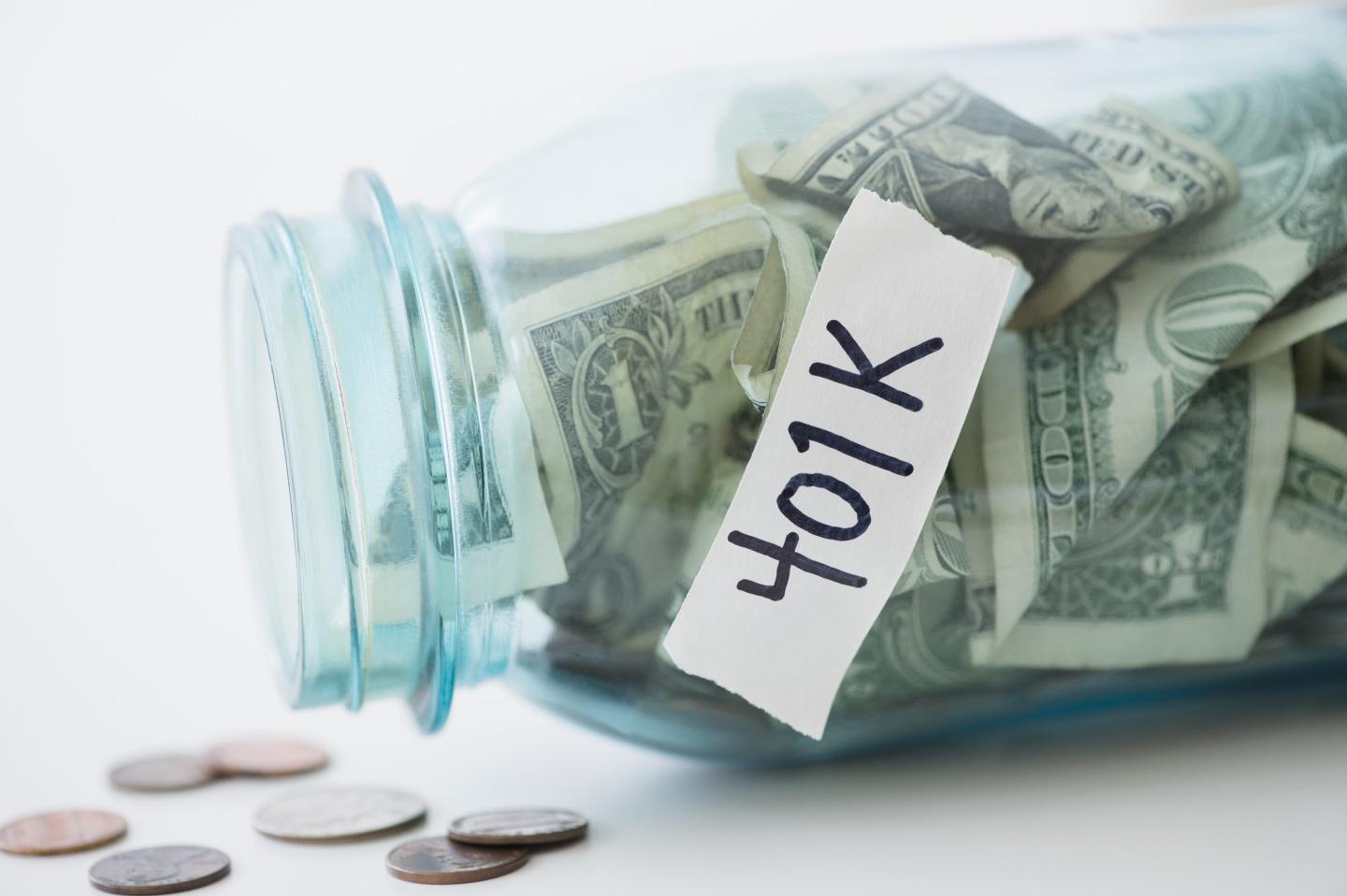 A jar with a label saying "401K" is on its side with money spilling out