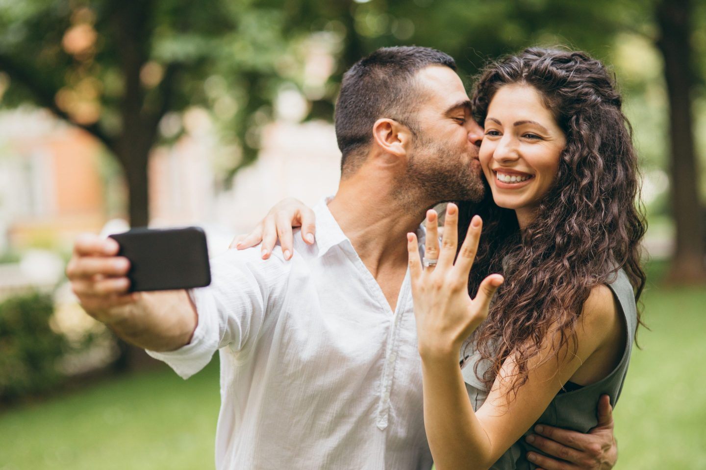 couple posing with engagement ring