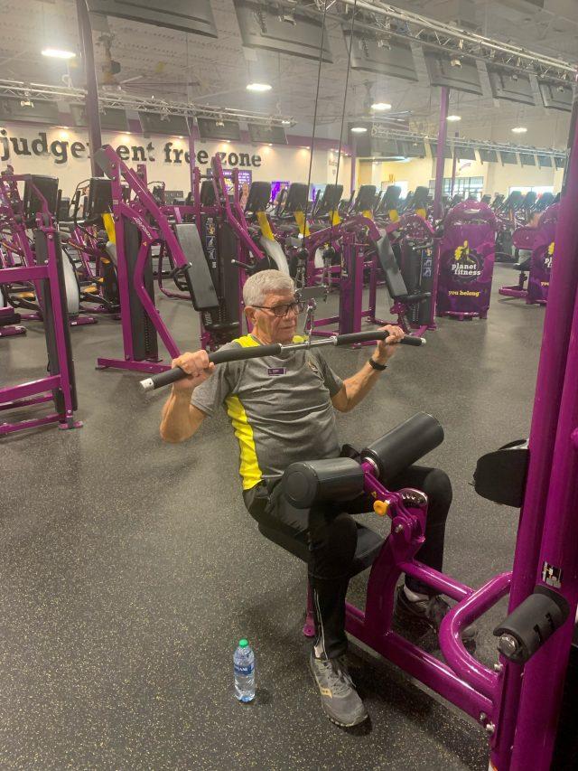 Older adult lifting weights at a gym