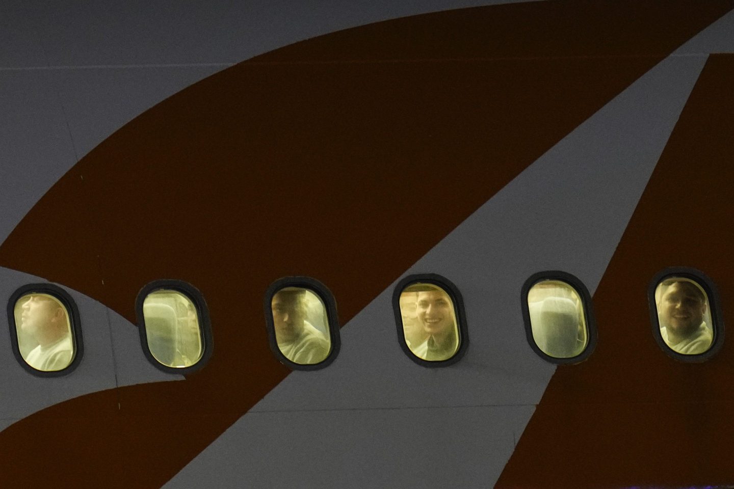 Venezuelan migrants deported from the United States peer through their plane window as they arrive at Simon Bolivar International Airport in Maiquetia, Venezuela, on March 24, 2025.