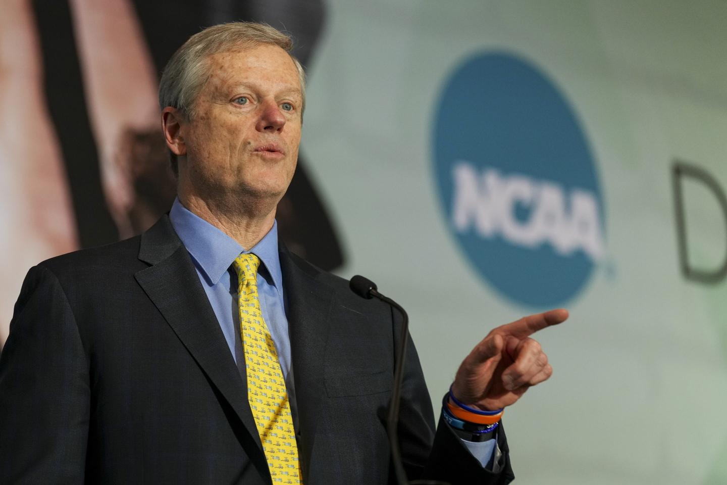 NCAA President holds his index finger up, as if he was expecting a bird to land on it. Does he think he's Snow White?