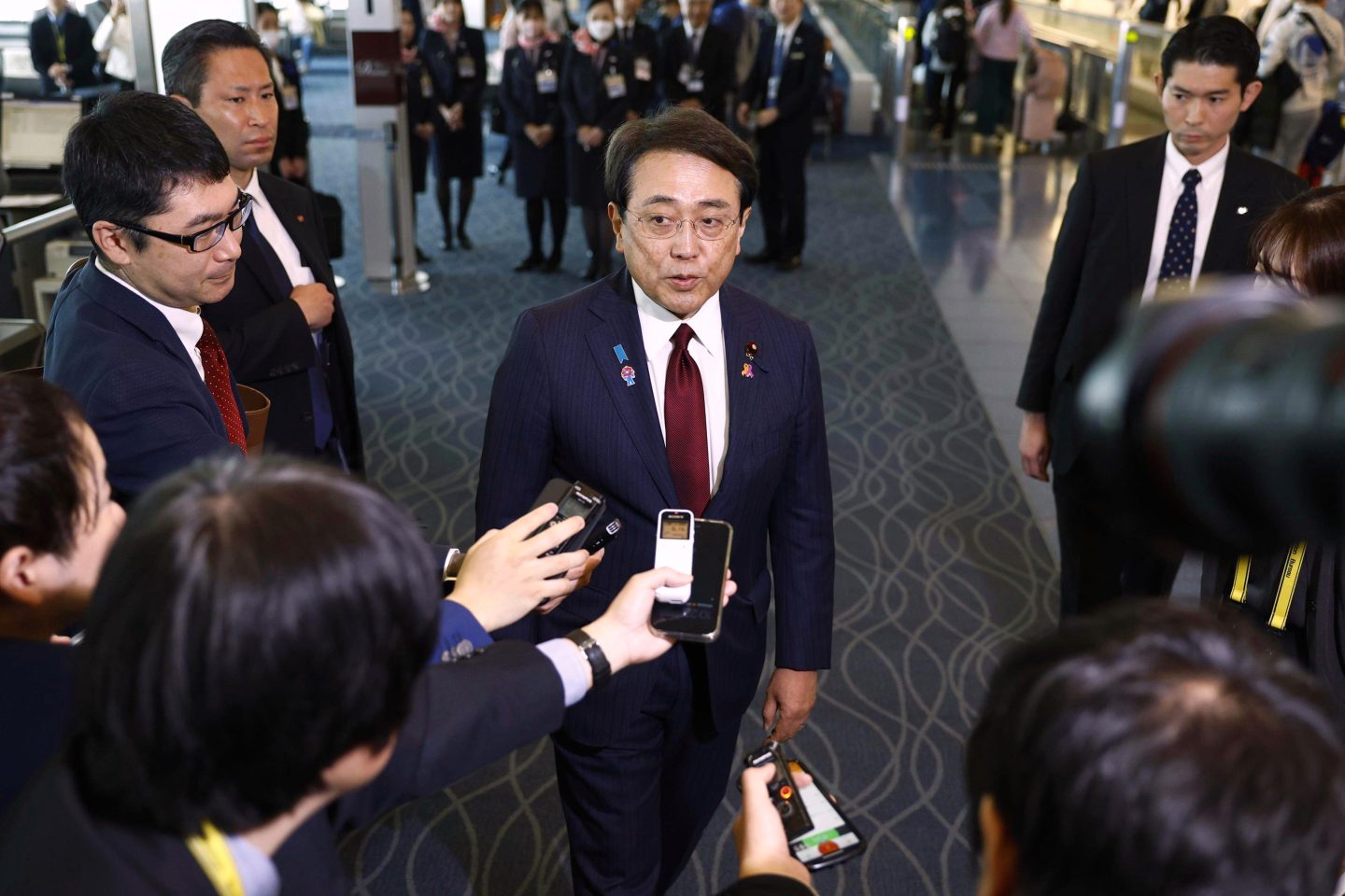 Japan's chief trade negotiator and Economic Revitalization Minister Ryosei Akazawa, center, speaks to the reporters before this departure for the U.S., at Haneda airport in Tokyo, on April 16, 2025.