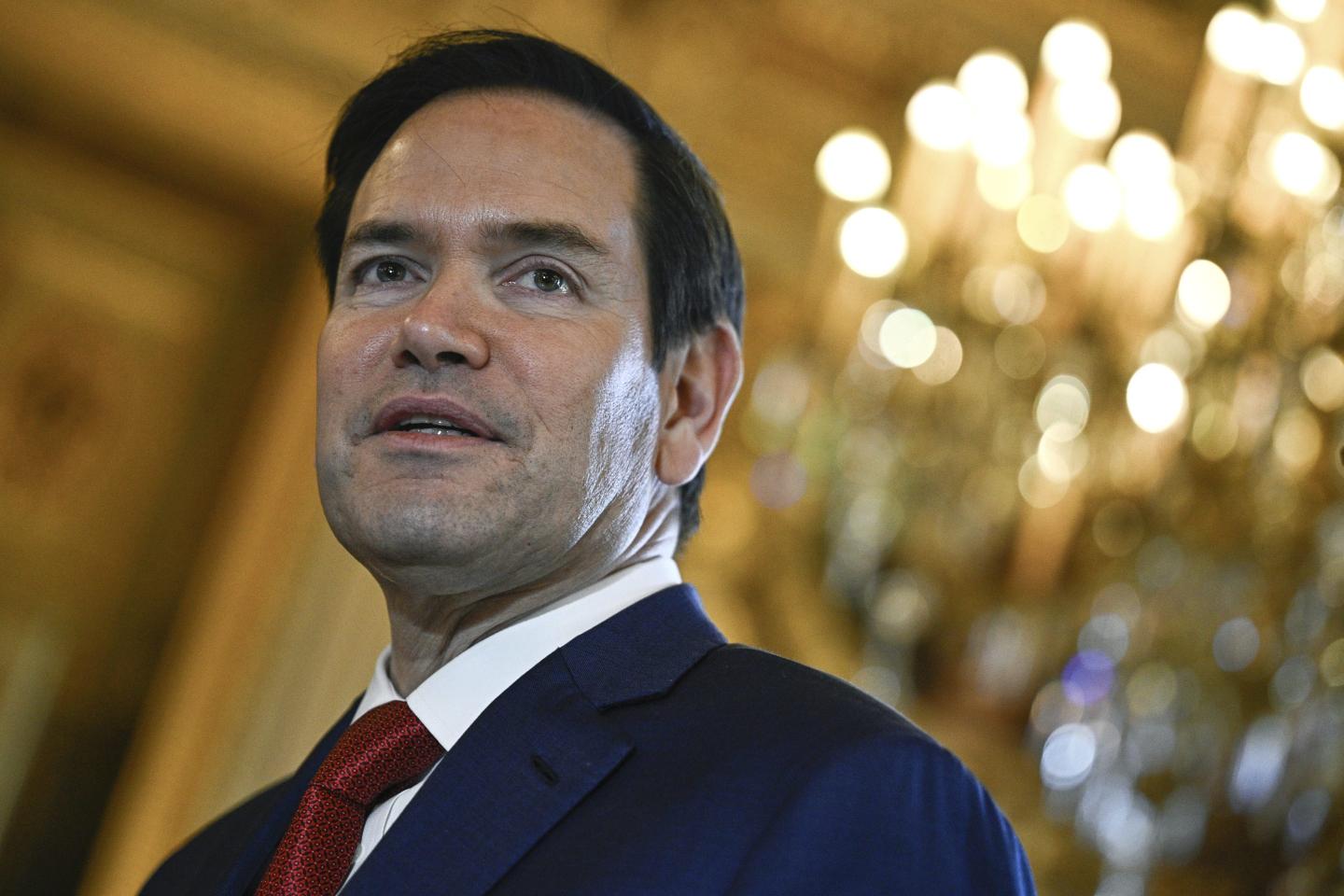 Marco Rubio with a chandelier in the background