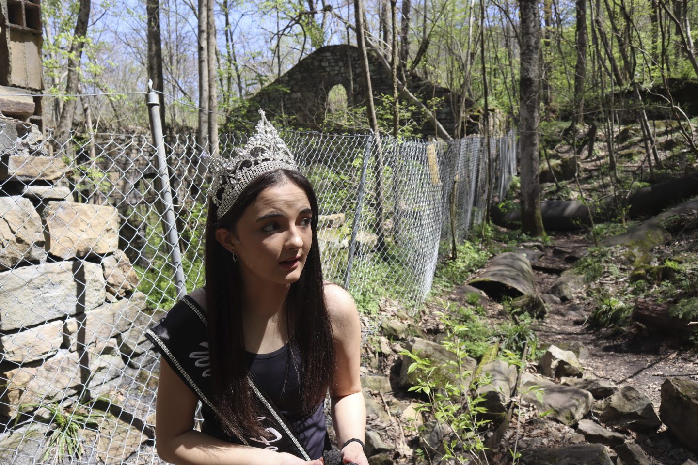 West Virginia Coal Festival teen beauty pageant winner Ava Johnson, 16, collects small pieces of coal left behind at the former Kay Moor coal town and camp in the New River Gorge National Park and Preserve near Fayetteville, W.Va., Thursday, April 17, 2025