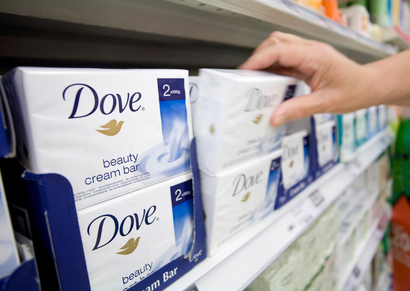 A customer selects a packet of Dove soap at a grocery store