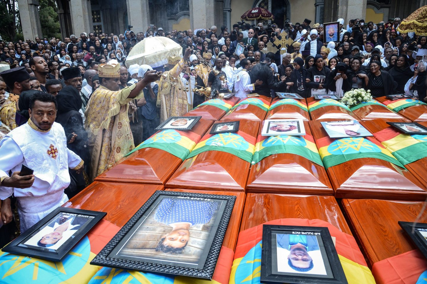Priests hold a ceremony beside coffins of victims of the crashed accident of Ethiopian Airlines during the mass funeral at Holy Trinity Cathedral in Addis Ababa, Ethiopia, on March 17, 2019.