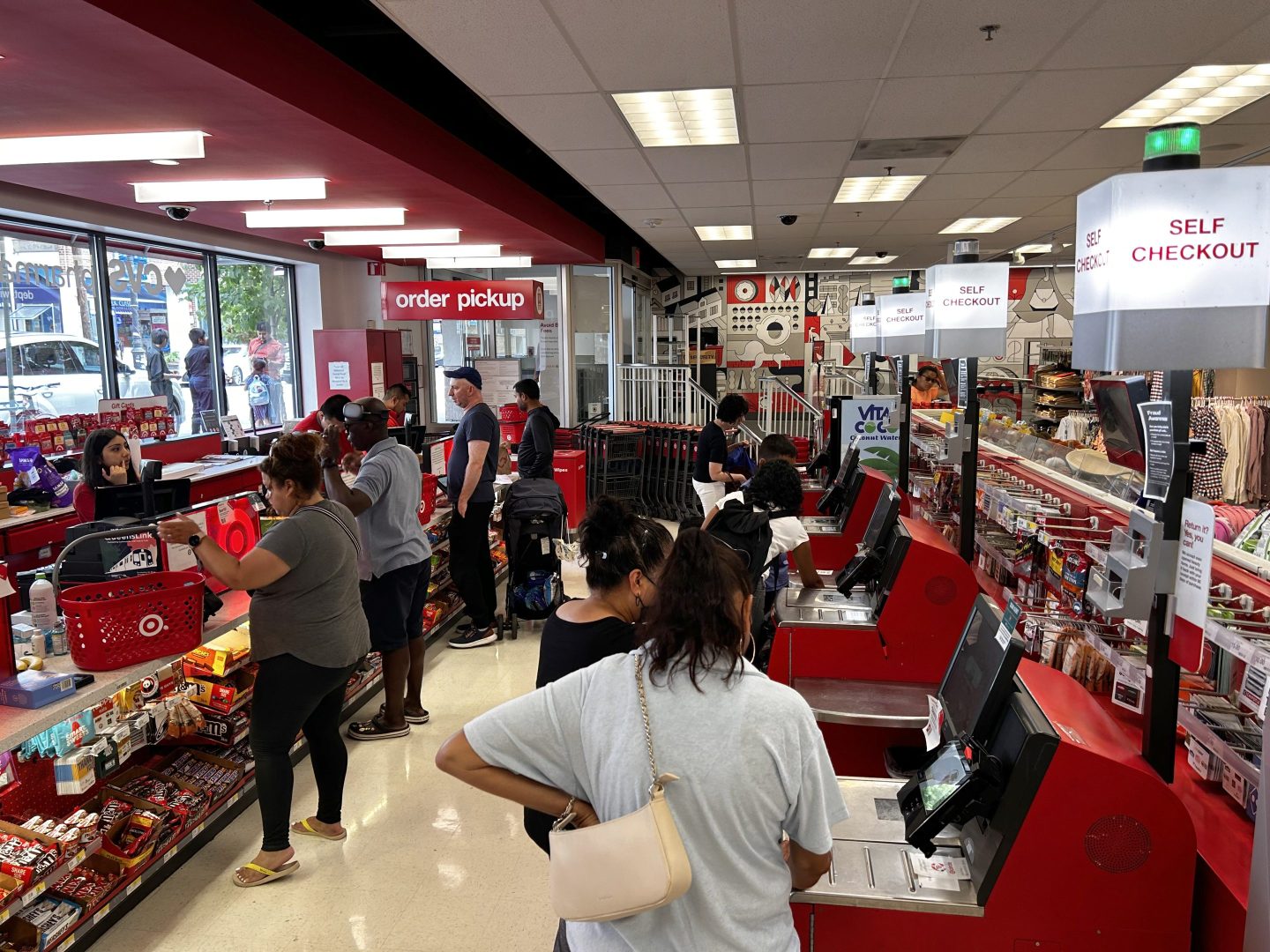 A busy self-checkout across from a busy cashier check out at a Target Store in Queens, New York.