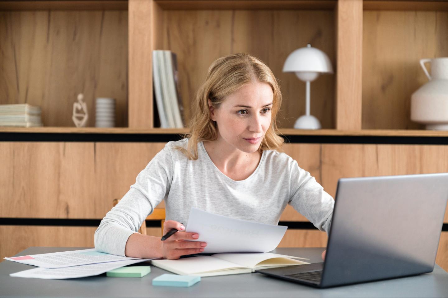 Female HR recruiter holding resumes and having online virtual interview