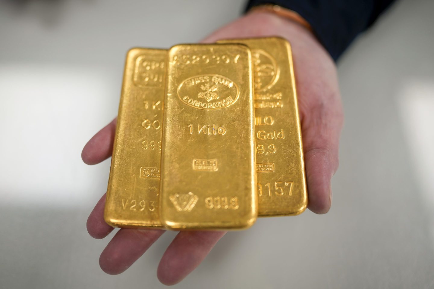 Three gold bars in a hand.