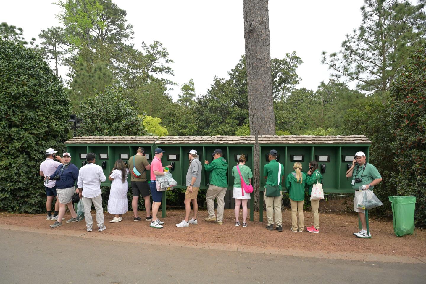people standing at telephones at masters tournament