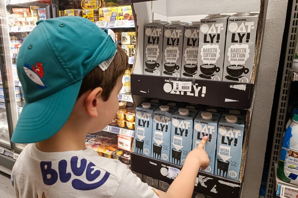 a child looking at Oatly cartons in a Paris supermarket.