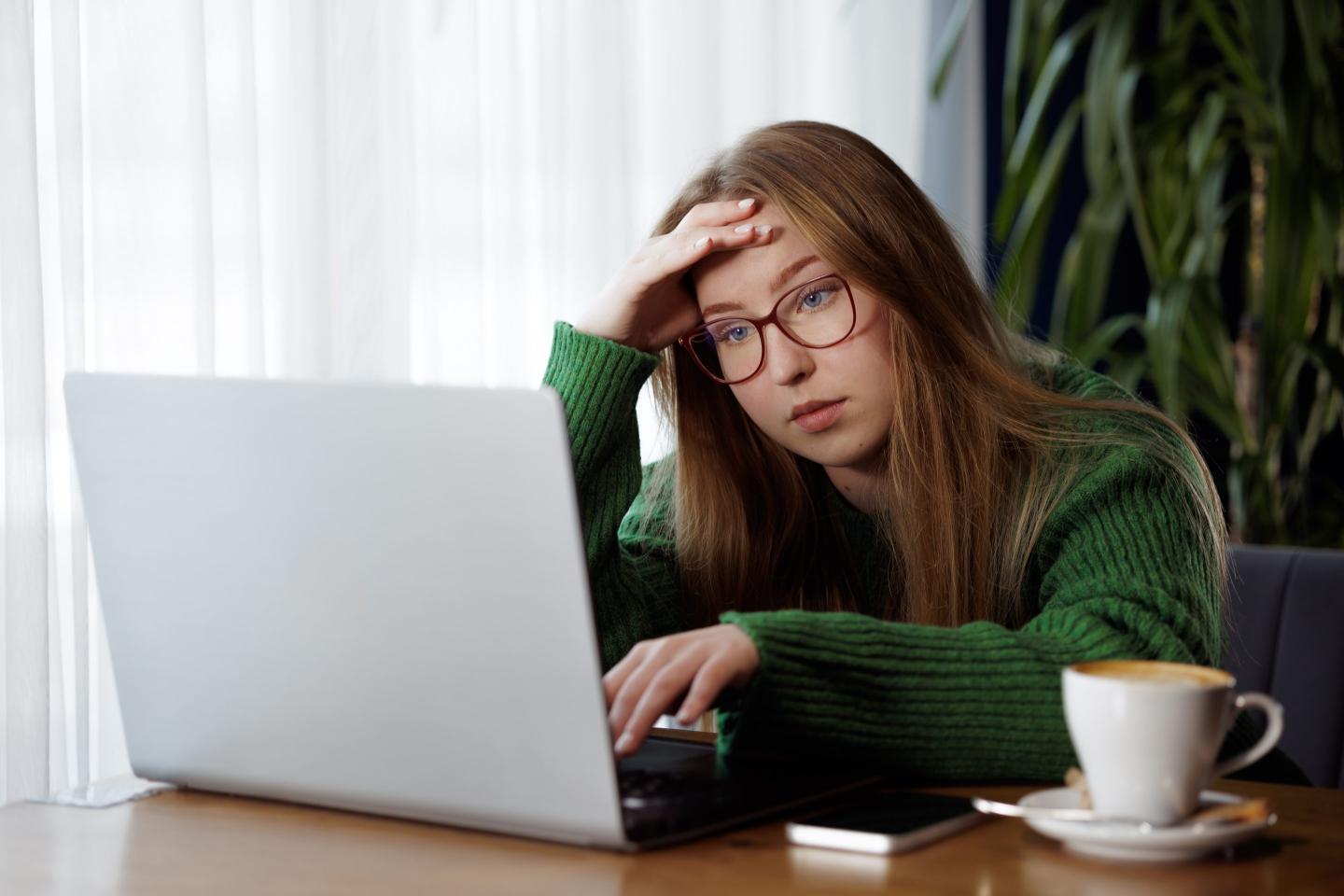 Distressed young girl at laptop
