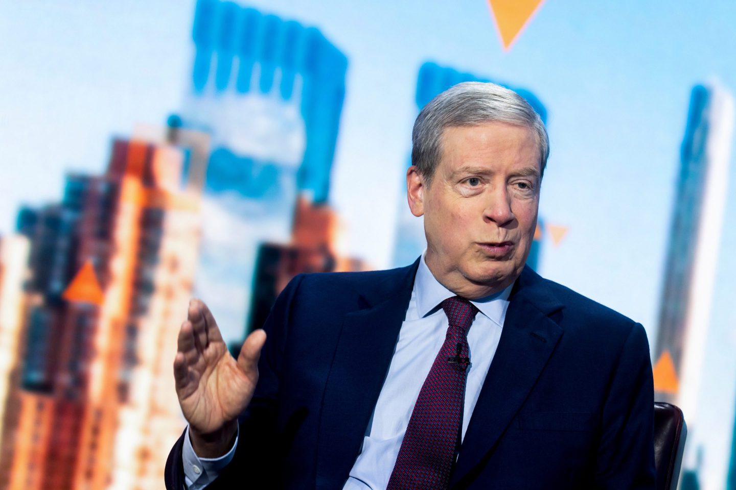 Stan Druckenmiller lifts his right hand as he talks.