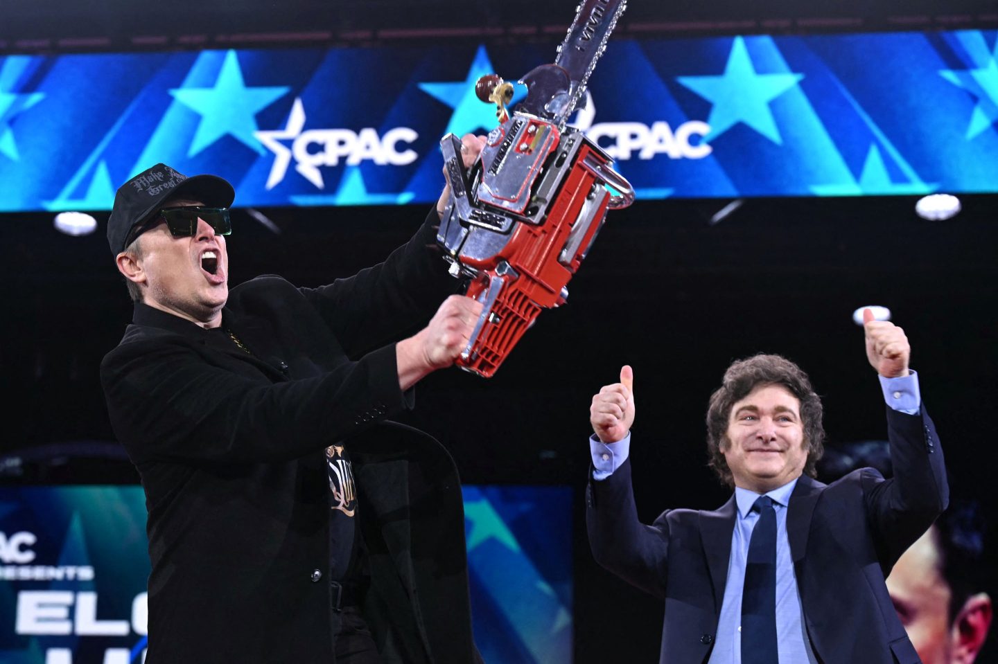 Elon Musk (L) holds a chainsaw alongside Argentine President Javier Milei during the annual Conservative Political Action Conference (CPAC) on February 20, 2025.