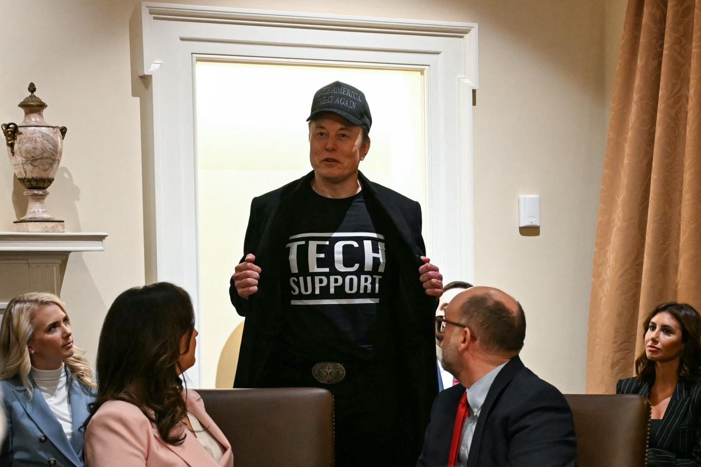 Elon Musk wearing a “tech support” T-shirt.