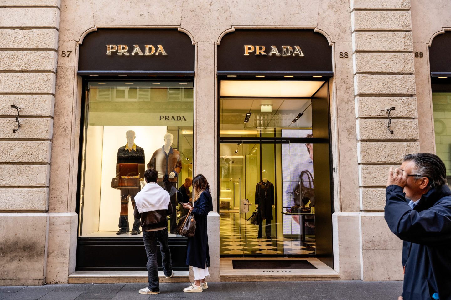 people walking outside prada store