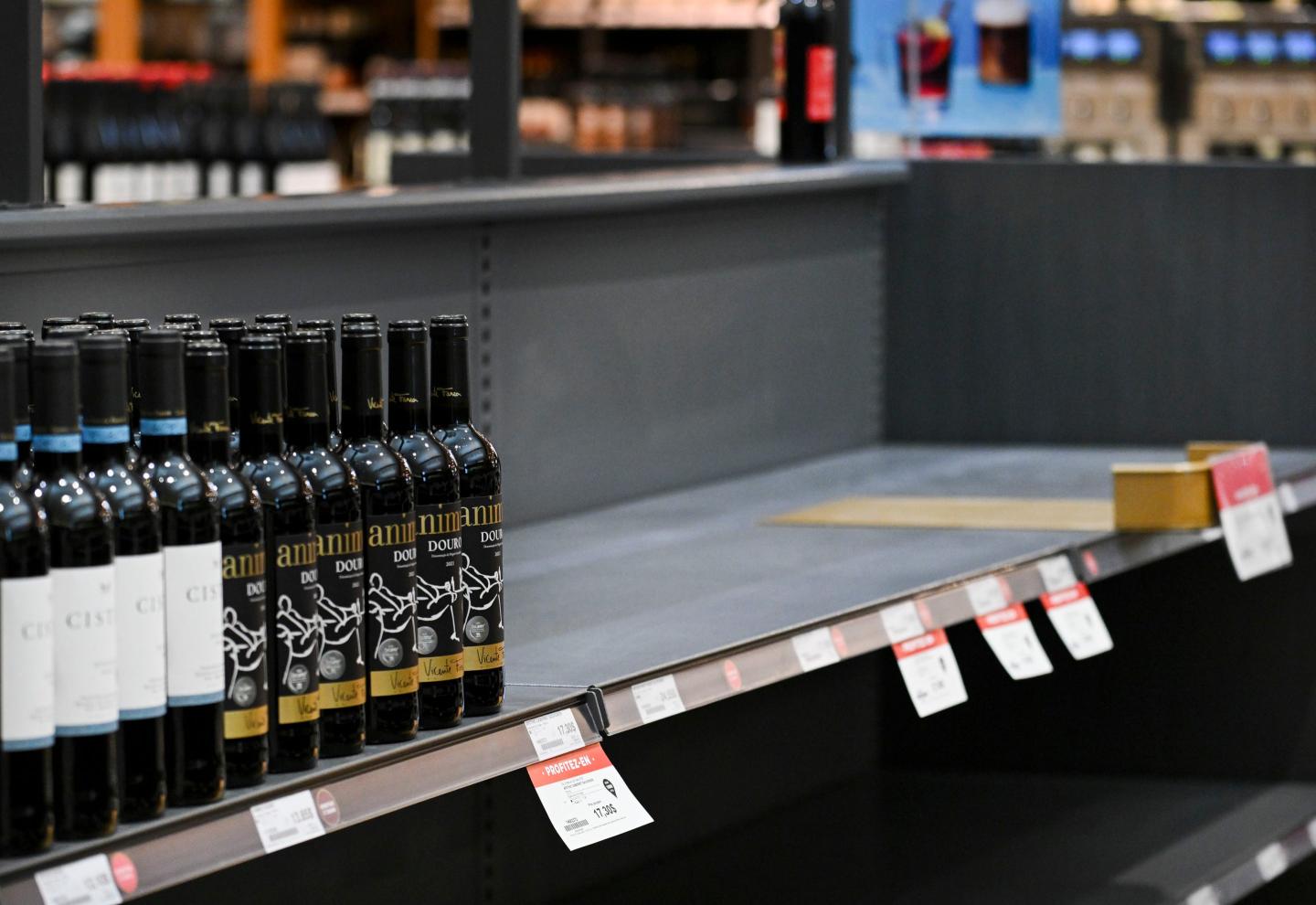 A wine shelf is half-empty
