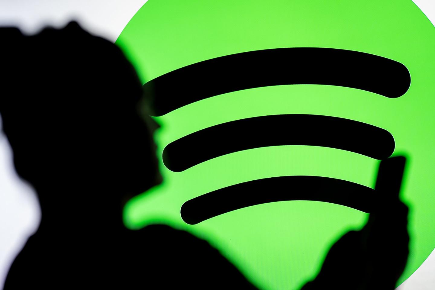 A silhouette of a woman in front of the Spotify logo
