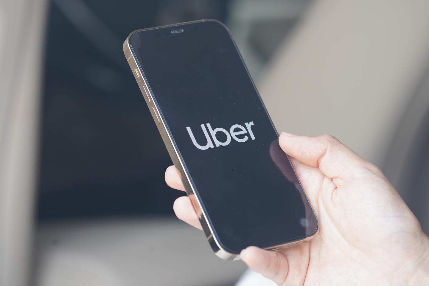 Someone holding a photo with the Uber app loading