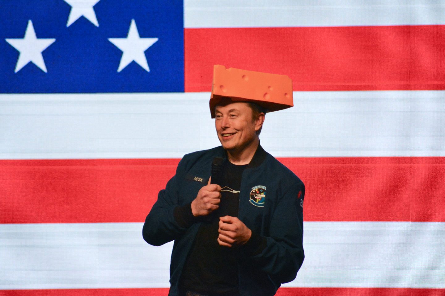 Elon Musk wears a cheesehead hat as he speaks during a town hall in Green Bay.