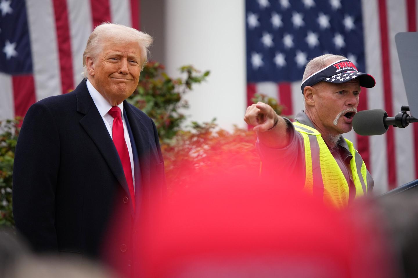 UAW member Brian Pannebecker speaks at podium with Trump watching