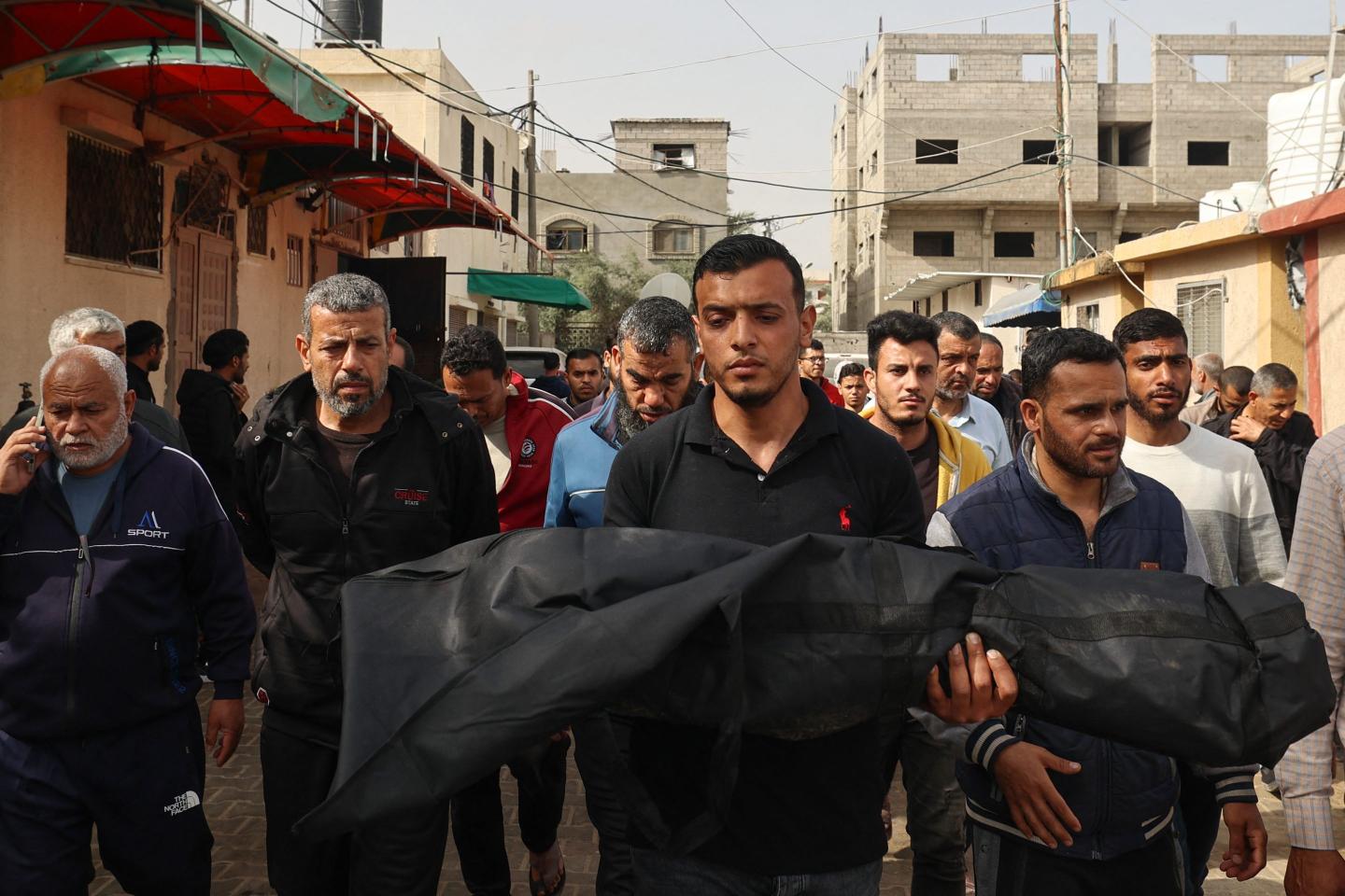 Men carry a body of a child killed in an airstrike carried out by Israel