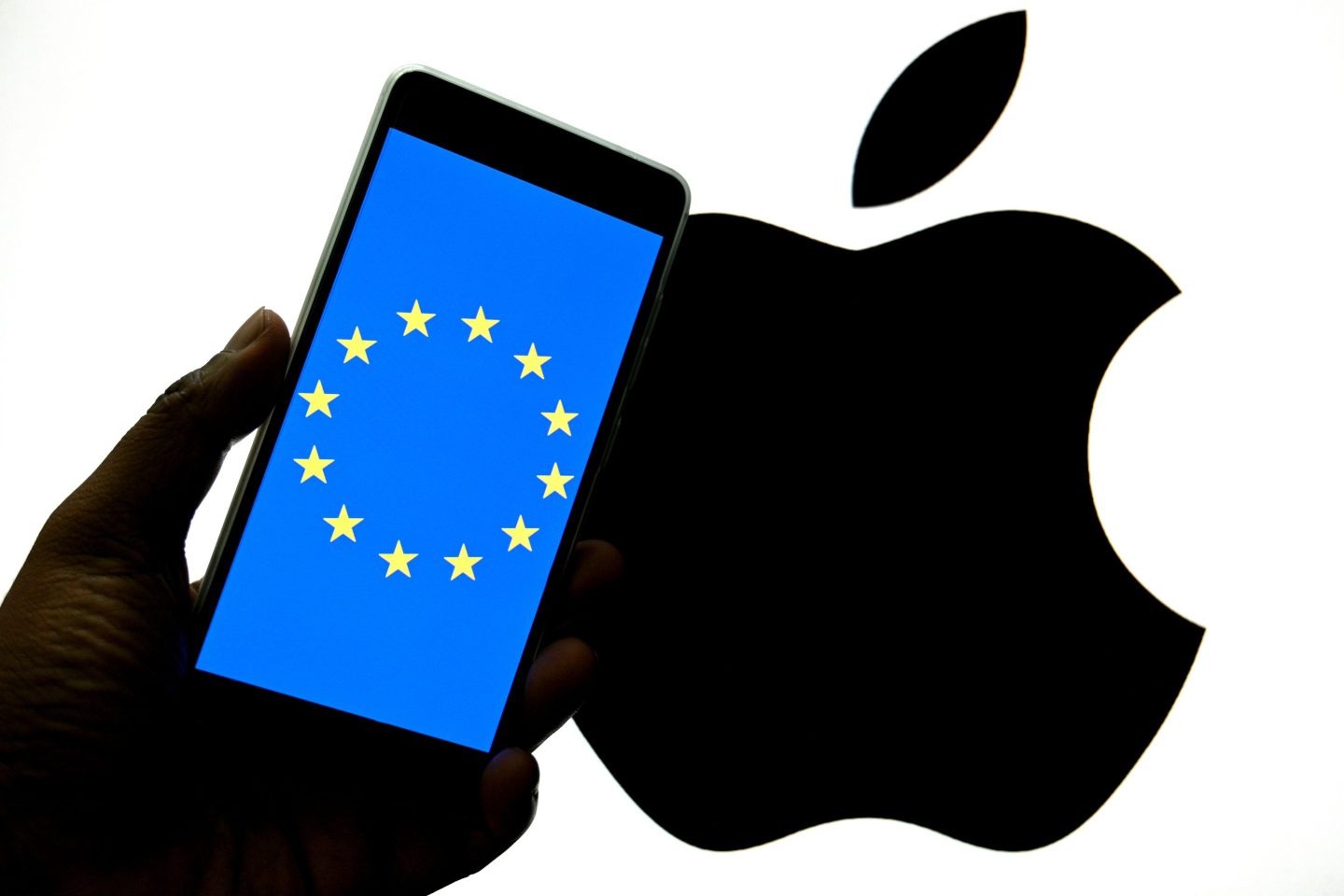 A phone with the European Union logo on top of the Apple logo