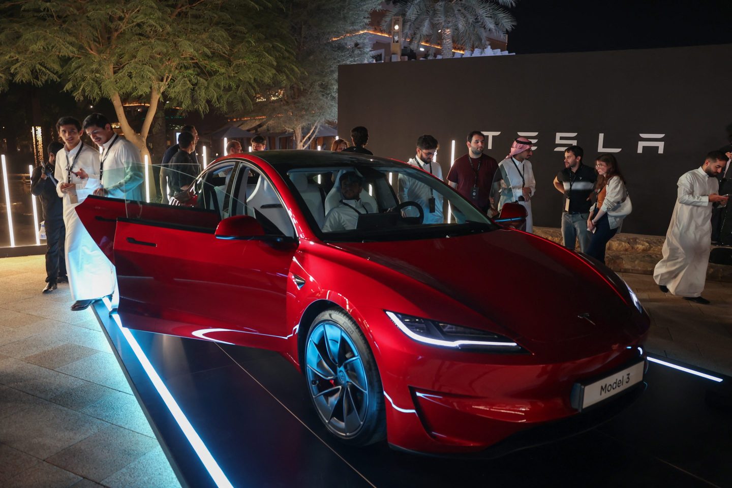 People check out a car on display during Tesla's official launch ceremony in Riyadh