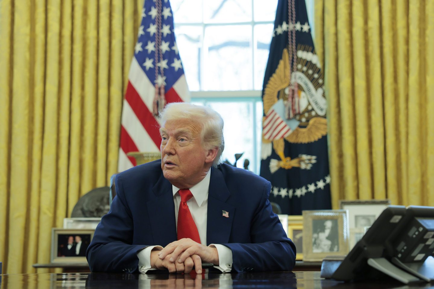 President Donald Trump speaks to reporters while in the Oval Office