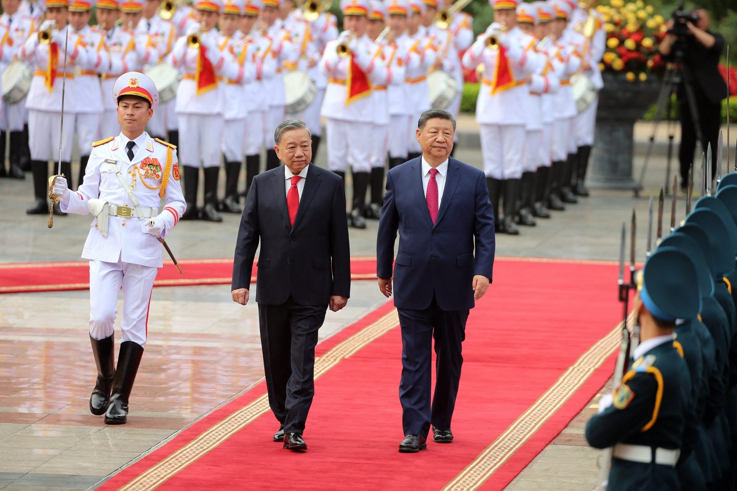 Vietnam’s General Secretary of the Communist Party, To Lam (center), and Chinese President Xi Jinping (right) review the guard of honor during a ceremonial welcome at the Presidential Palace in Hanoi on April 14, 2025.