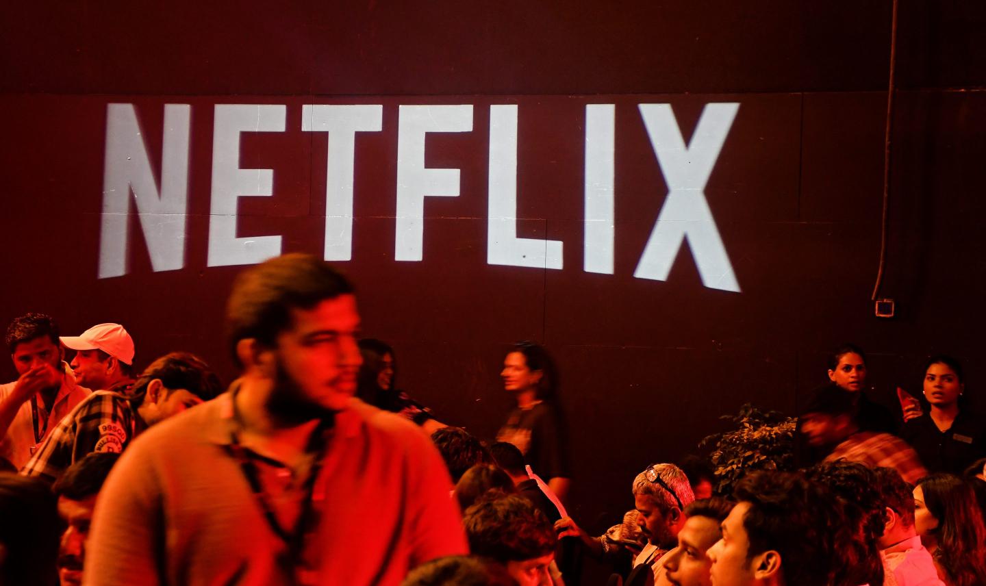 Netflix logo is seen displayed at the trailer launch of the film 'Jewel Thief' as people mill about.