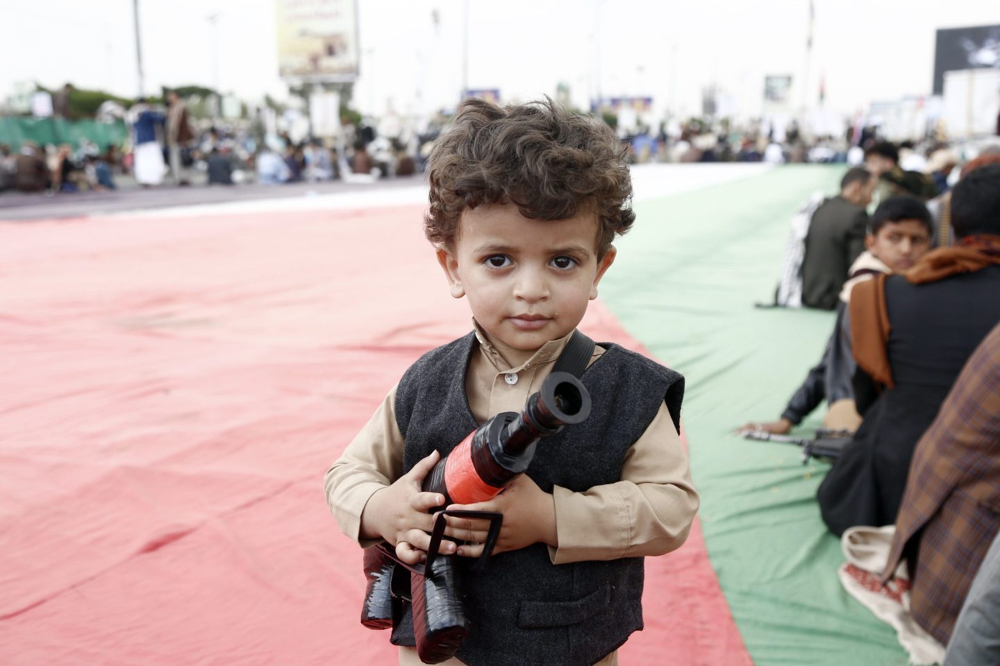 A Yemeni child holds a fake gun at a protest supporting the Houthi rebels