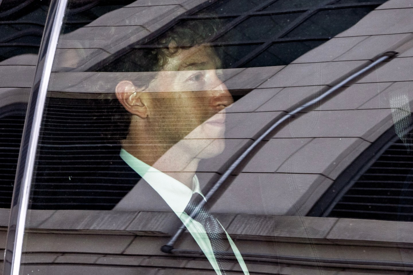 Mark Zuckerberg can be seen through a car window.