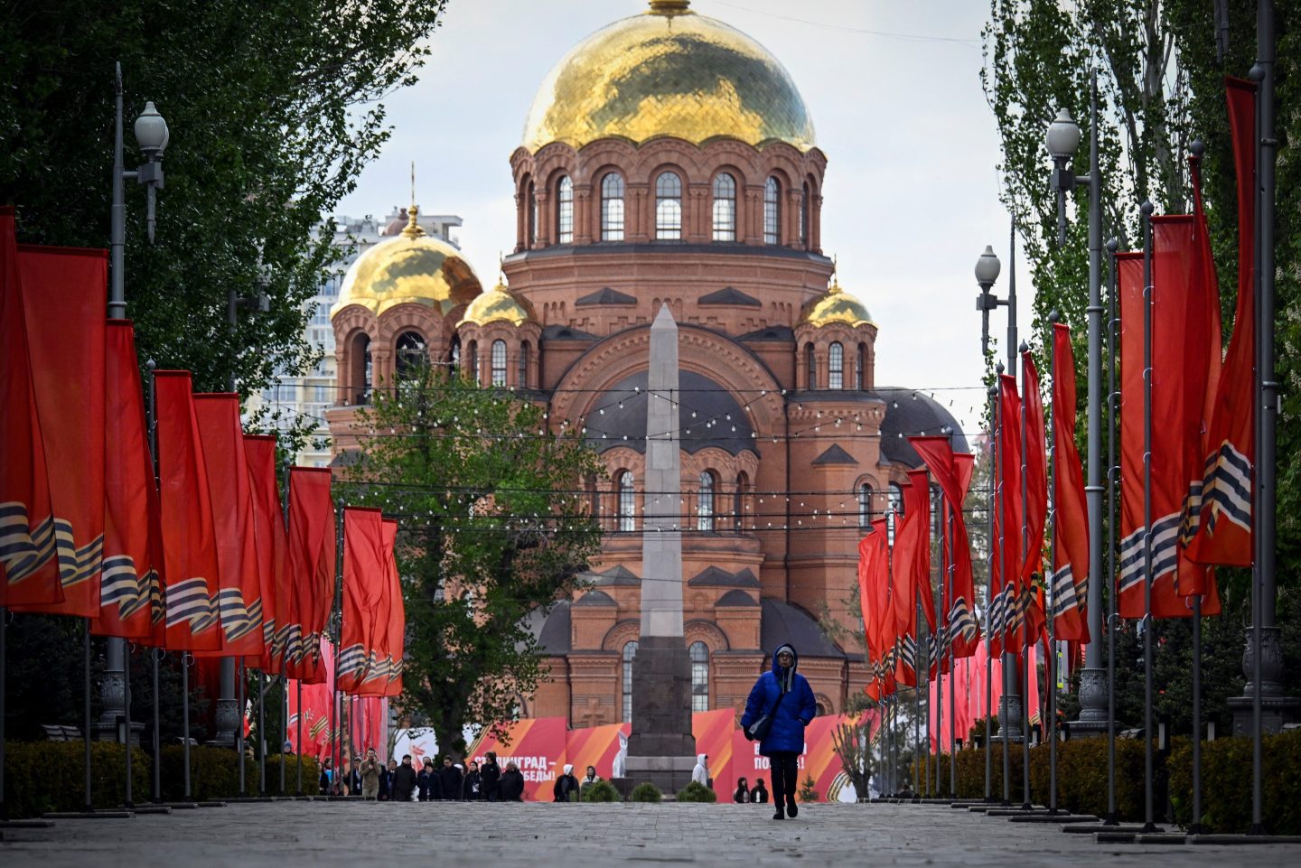 A woman walks past decorations for Russia's Victory Day, prior to the 80th anniversary of the victory over Nazi Germany during World War II, in central Volgograd on April 28, 2025.