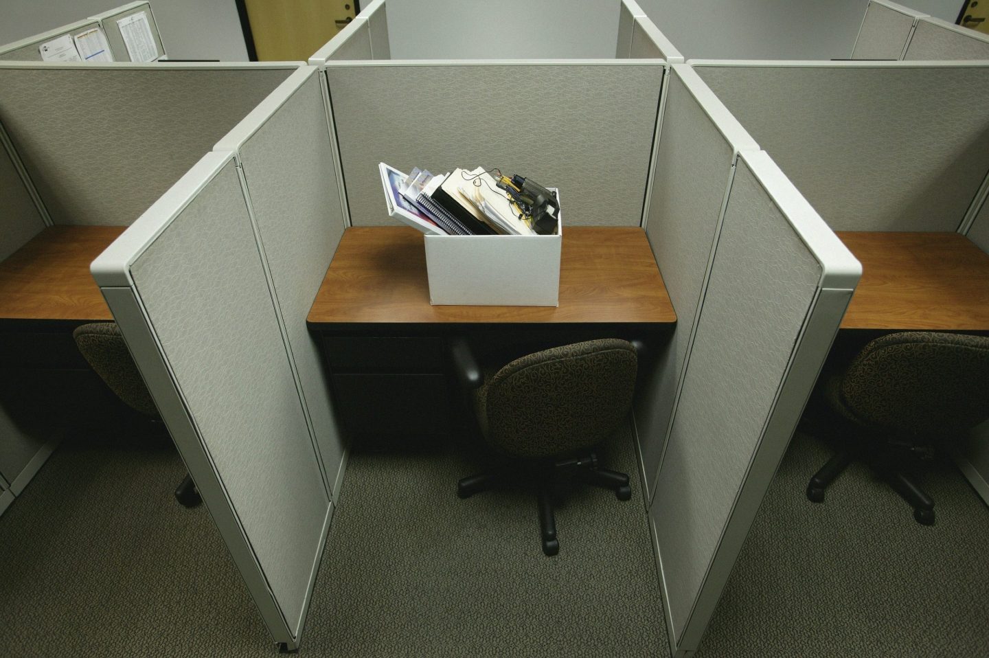 An empty cubicle in an office to suggest someone being let go.