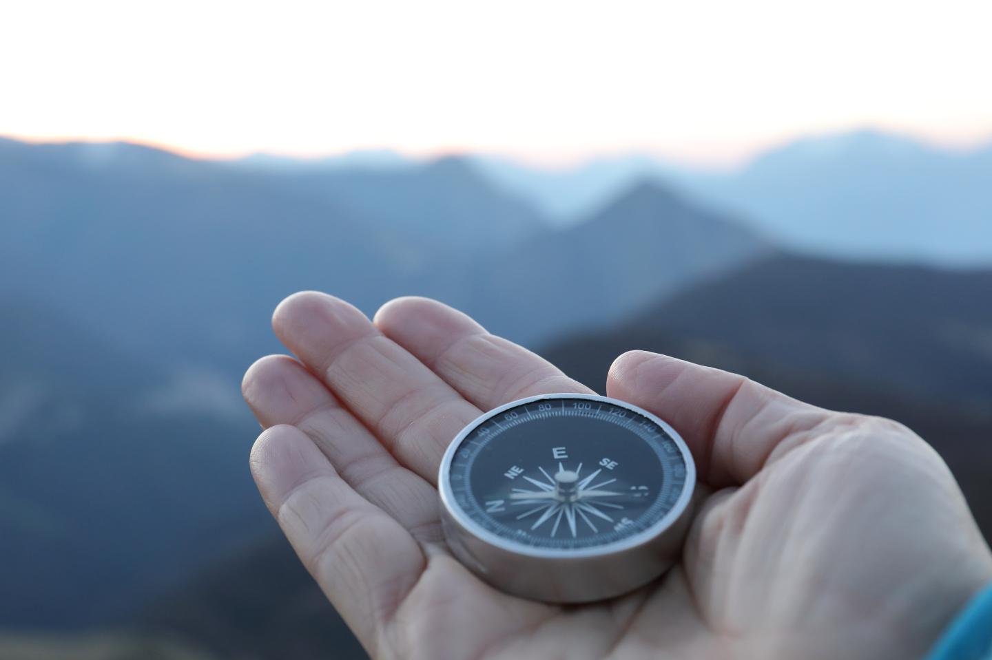 Photo: A hand holding a compass.