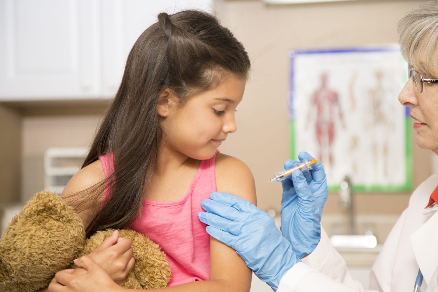Young girl getting a vaccination from a female doctor