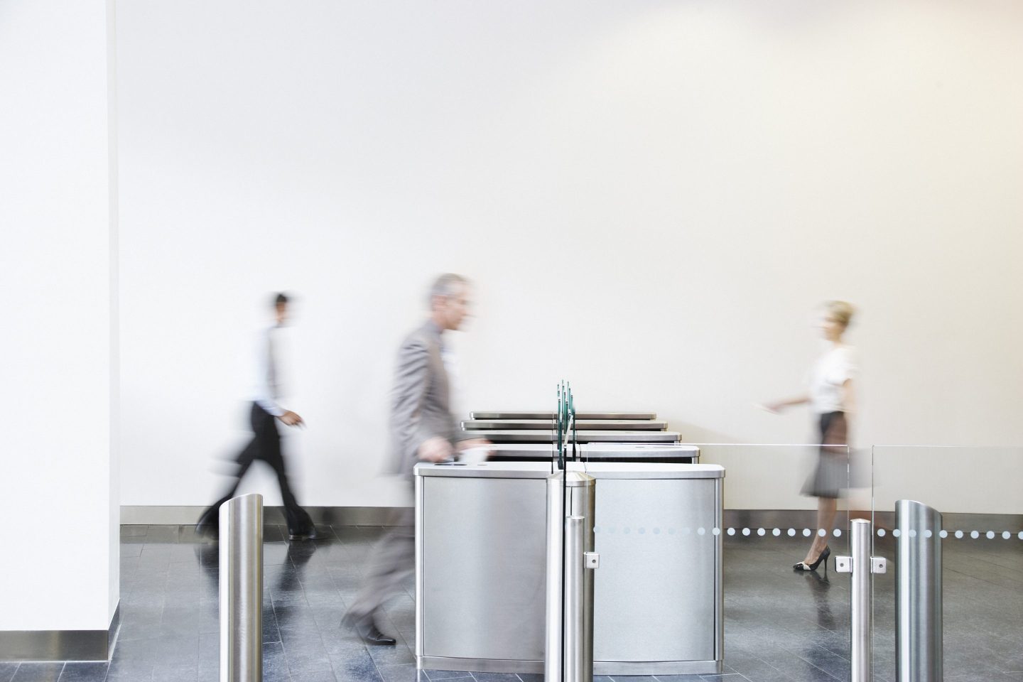 Businesspeople walking through turnstile