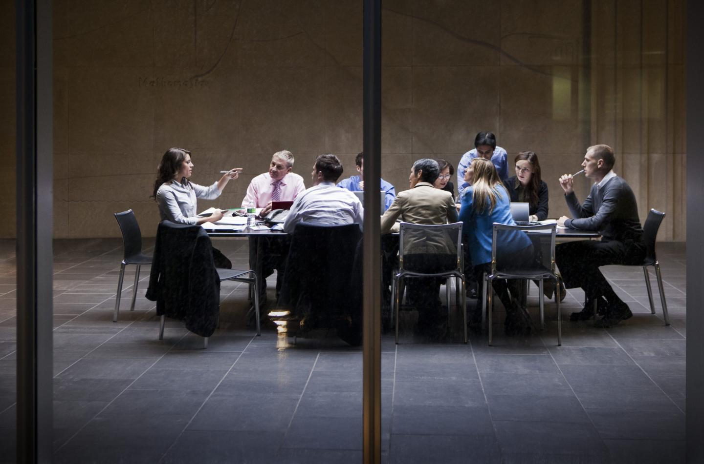 Office workers in a business meeting around a table.